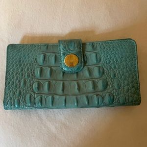 This is a teal blue Brahmin wallet in excellent condition.
